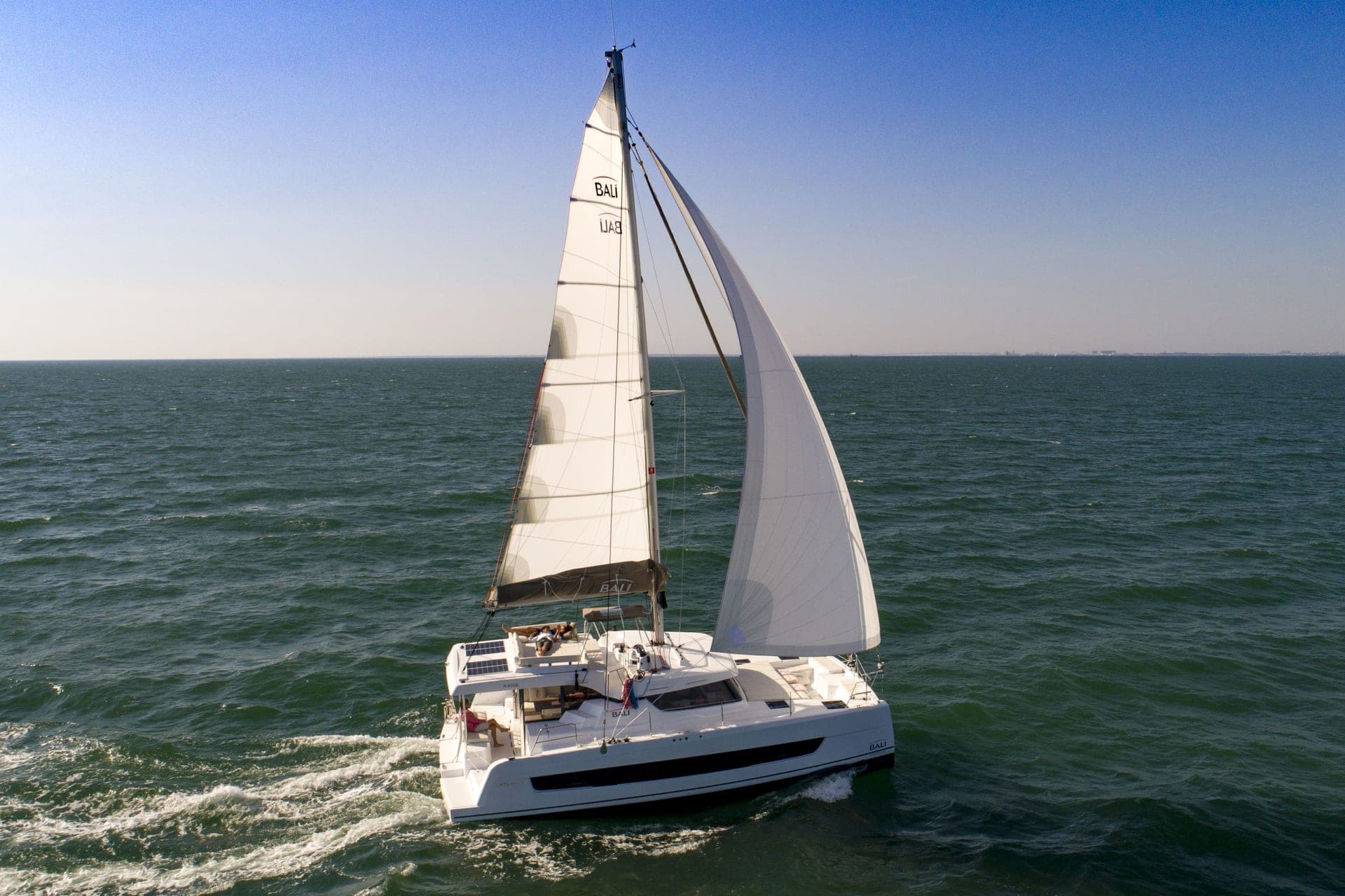 Bali Catspace en navigation sous grand-voile et gennaker, vue aérienne de profil