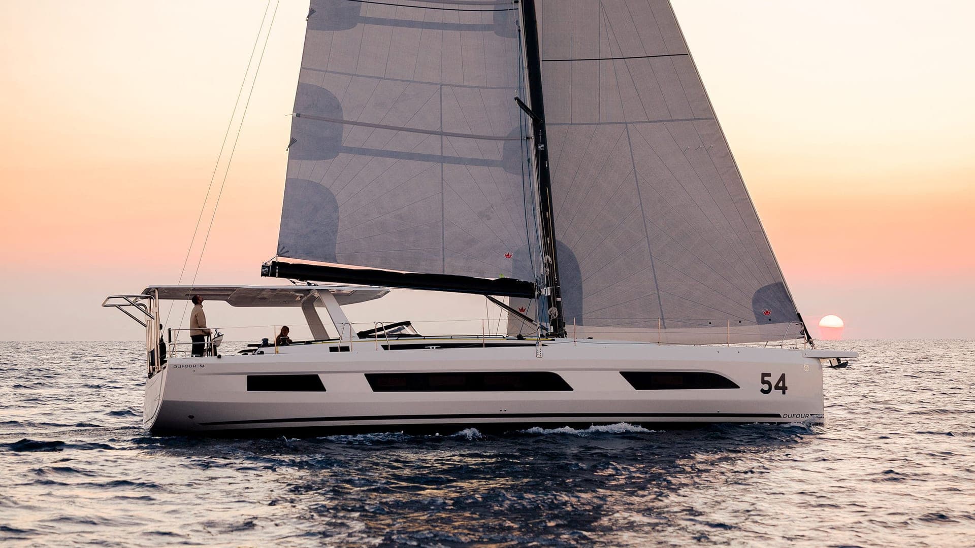 Dufour 54 sous voiles au coucher du soleil, vue de profil