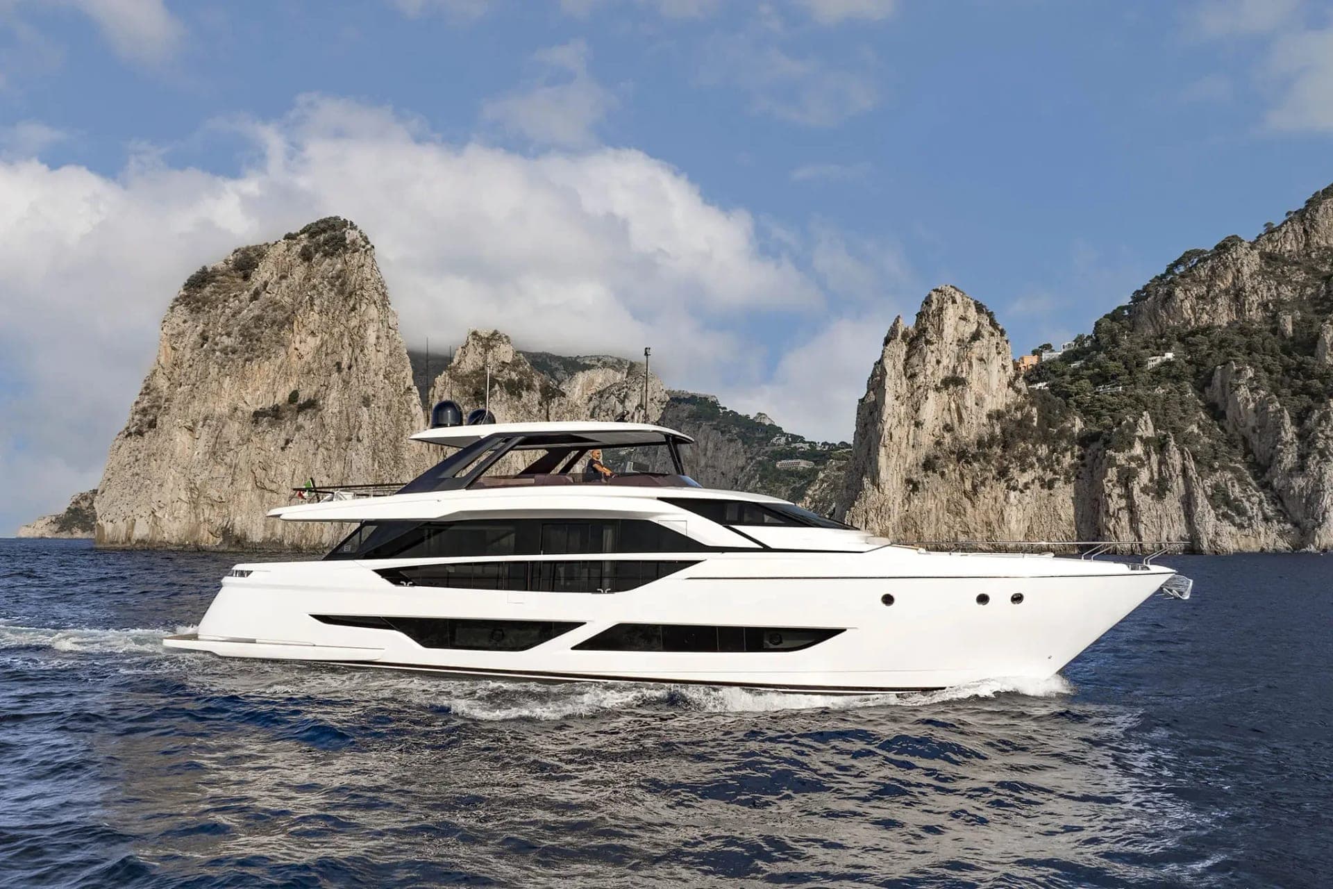 Ferretti Yachts 860 vu de profil en navigation le long d'une côte rocheuse