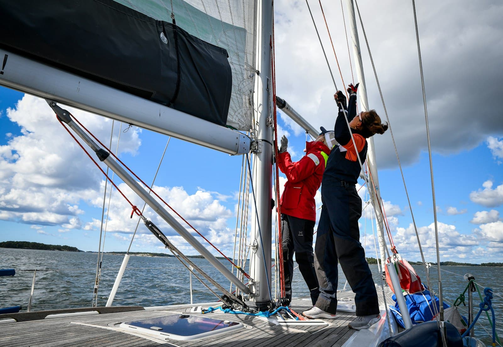 Équipiers réglant les voiles sur le pont d'un voilier