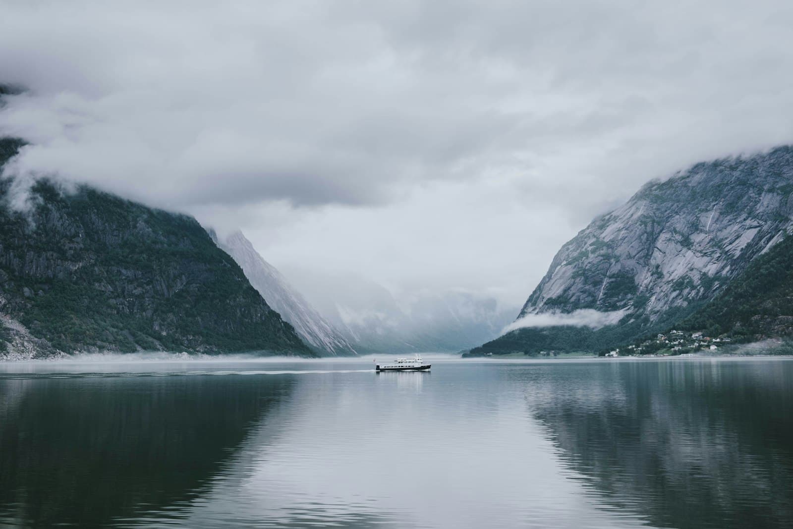 Bateau naviguant au cœur d'un fjord norvégien